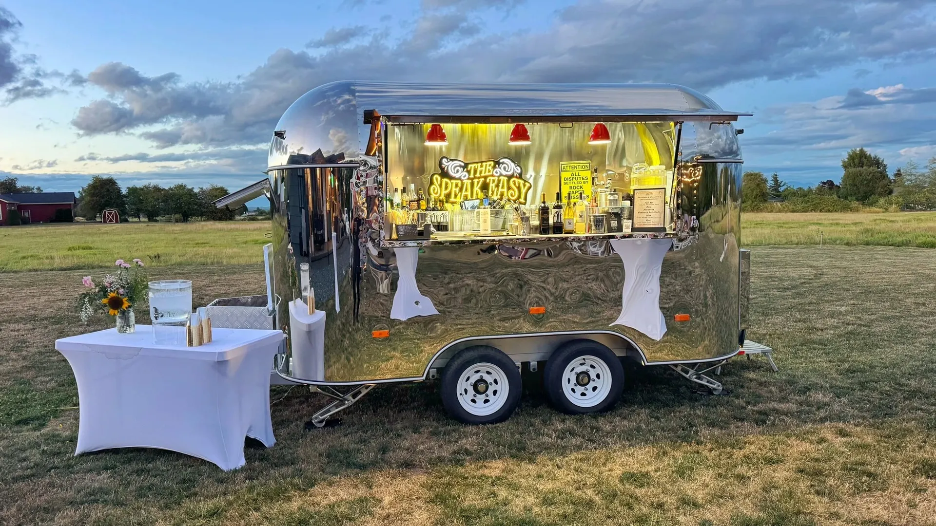 The Speak Easy vintage mobile bar trailer set up in a field